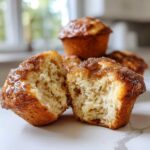 A cinnamon sugar french toast muffin cut in half showing its soft, fluffy interior texture.