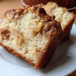 Close-up of two moist slices of Jewish apple cake showing tender crumb and caramelized apples.