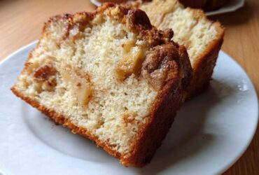 Close-up of two moist slices of Jewish apple cake showing tender crumb and caramelized apples.