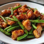 Close-up of saucy, glazed chicken and bright green beans, the perfect 30-minute chicken and green beans dish.