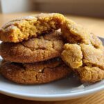 A stack of three soft, chewy brown butter sugar cookies, one broken open to show the texture.