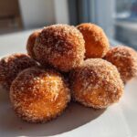 A stack of freshly made cinnamon sugar snowball cookies coated heavily in sparkling sugar.