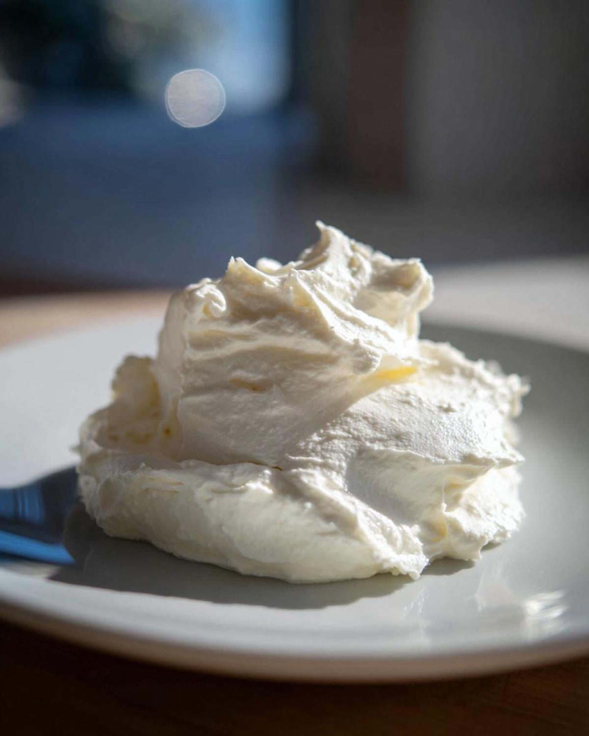A dollop of thick, white creamy horseradish sauce served on a light gray plate.