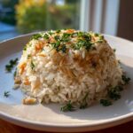 A perfectly molded mound of fluffy rice pilaf mixed with toasted vermicelli and topped with fresh parsley.