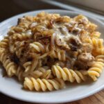 Close-up of a serving of creamy french onion pasta made with fusilli, caramelized onions, and melted cheese.