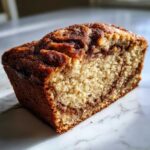 Close-up of a slice of snickerdoodle zucchini bread showing the moist crumb and cinnamon swirl.
