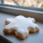 A single, star-shaped sugar cookie topped with thick, glossy white sugar cookie icing recipe.