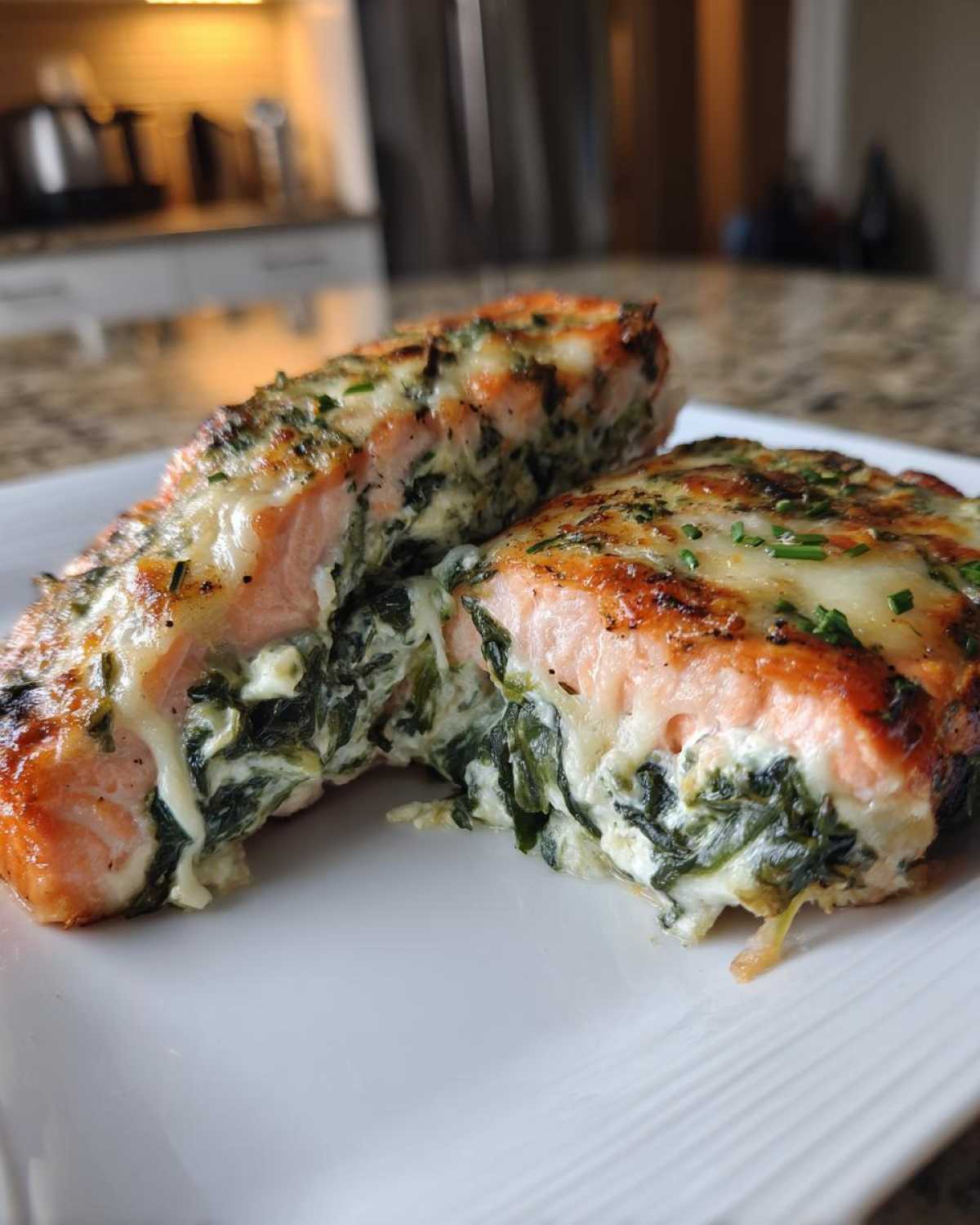 Two halves of baked stuffed salmon showing creamy spinach filling inside the perfectly cooked salmon.