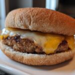 Close-up of a juicy Air Fryer Turkey Burger topped with melted white and yellow cheese on a whole wheat bun.