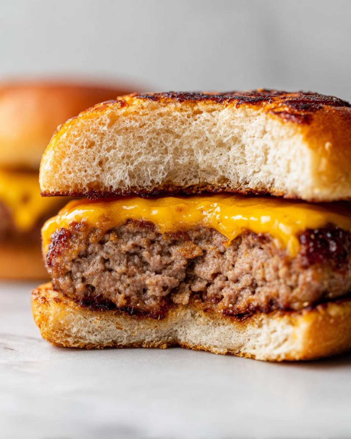 Close-up of an Air Fryer Turkey Burger cut in half showing the juicy interior and melted cheese on a toasted bun.