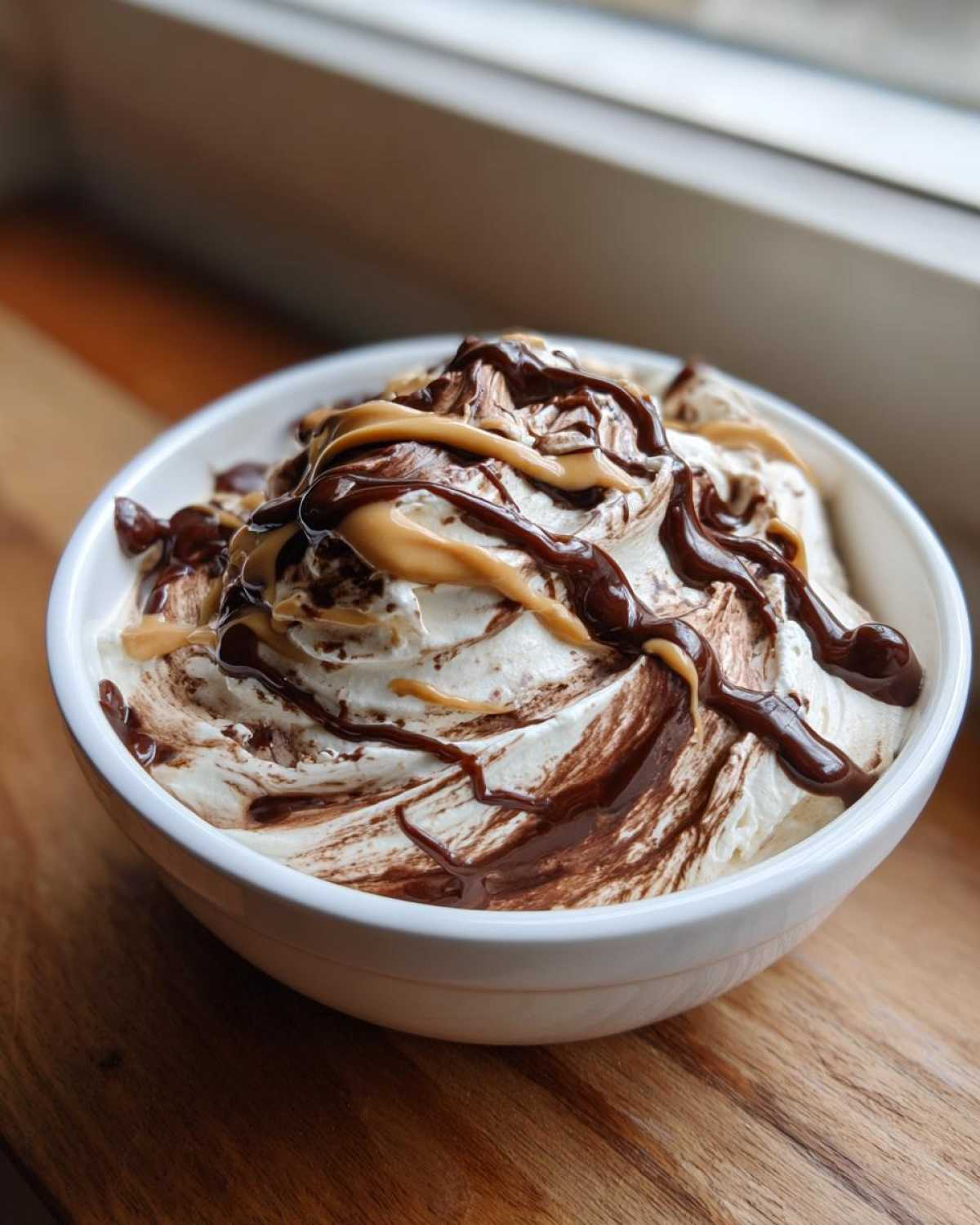 Close-up of creamy Chocolate Peanut Butter Cheesecake Dip topped with chocolate and peanut butter drizzles.