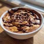 Close-up of Chocolate Peanut Butter Cheesecake Dip swirled with peanut butter and drizzled with chocolate sauce.