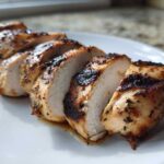 Close-up of sliced Copycat Chipotle Chicken breast showing juicy white meat and charred, seasoned exterior.