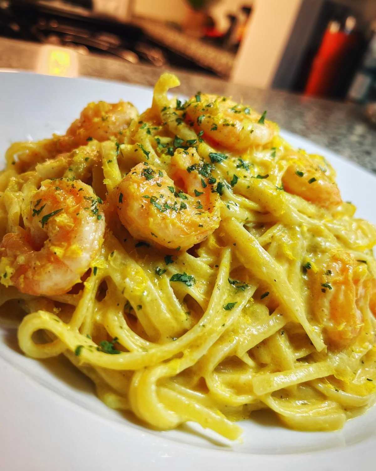 Close-up of Creamy Lemon Garlic Shrimp Pasta with fettuccine noodles, topped with shrimp and parsley.