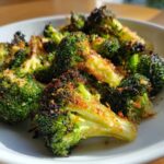 Close-up of bright green broccoli florets coated in golden brown, crispy Parmesan cheese.