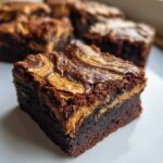 A rich, fudgy square of Dark Chocolate Tahini Brownies featuring a beautiful swirl of tahini on top.
