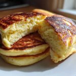 Close-up of fluffy Gluten-Free Buttermilk Pancakes, one broken open to show the airy interior.