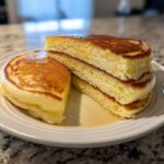 Close-up of fluffy Lemon Ricotta Pancakes stacked, showing the light, airy interior texture.