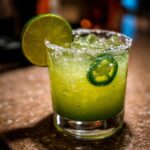 Close-up of a vibrant Fresh Jalapeño Lime Margarita garnished with a lime wheel and a jalapeño slice.