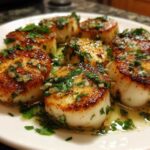 Close-up of seared Garlic Butter Scallops with Lemon, topped with fresh parsley and butter sauce.