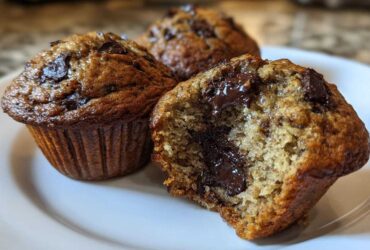 Close-up of three Gluten-Free Banana Chocolate Chip Muffins, one broken open showing melted chocolate chips inside.