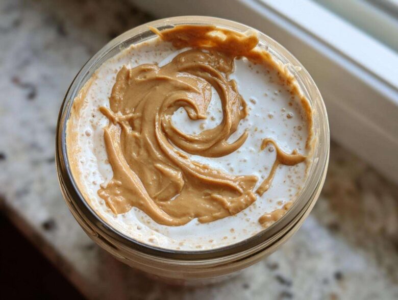 Overhead view of High-Protein Peanut Butter Overnight Oats topped with a beautiful swirl of creamy peanut butter.