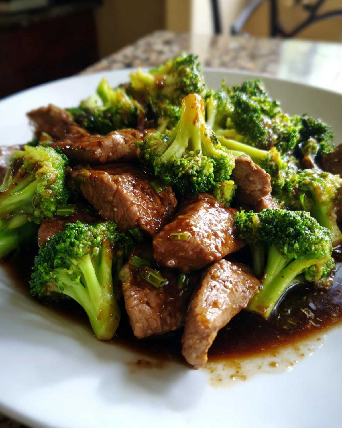 A close-up shot of tender pieces of beef coated in sauce served with bright green broccoli florets in Instant Pot Beef and Broccoli.