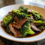A close-up of tender slices of beef coated in dark sauce mixed with vibrant green broccoli florets, representing Instant Pot Beef and Broccoli.