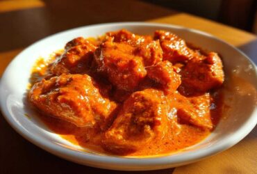 Close-up of tender chicken pieces coated in rich, vibrant orange sauce for Instant Pot Butter Chicken.