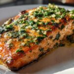 Close-up of a perfectly cooked Keto Garlic Butter Salmon fillet topped with melted butter, minced garlic, and fresh parsley.