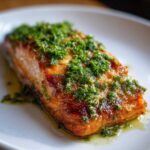 Close-up of a perfectly cooked Keto Garlic Butter Salmon fillet topped with fresh parsley and garlic butter sauce.