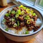 A close-up of Korean Ground Beef Bulgogi Bowls featuring savory ground beef over white rice, garnished with sesame seeds and sliced green onions.