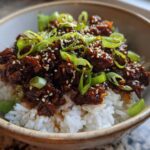 A close-up of Korean Ground Beef Bulgogi Bowls featuring savory ground beef over white rice, topped with green onions and sesame seeds.