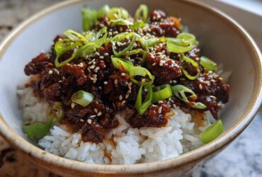 A close-up of Korean Ground Beef Bulgogi Bowls featuring savory ground beef over white rice, topped with green onions and sesame seeds.