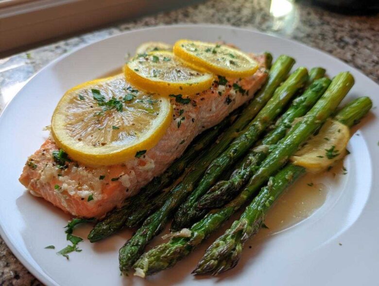 A serving of One-Pan Lemon Garlic Salmon with Asparagus topped with lemon slices and parsley.