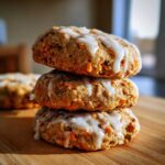 A stack of three Soft-Baked Carrot Cake Cookies topped with a thick cream cheese glaze.