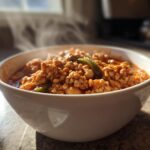 A close-up of a steaming white bowl filled with rich, hearty Spicy Turkey White Bean Chili.