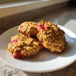 Three freshly baked Strawberry Oatmeal Breakfast Cookies stacked slightly on a white plate.