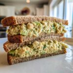 A tall, stacked Vegan Chickpea Salad Sandwich made with whole wheat bread and creamy filling.