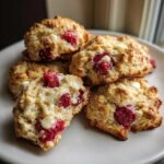 A stack of golden brown White Chocolate Raspberry Scones filled with bright red raspberries and melted white chocolate chips.