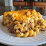 A generous serving of Cheesy Beef Pasta Bake with Cream Sauce featuring elbow macaroni, ground beef, and a melted cheddar cheese topping.