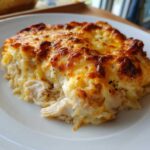 A close-up serving of Cheesy Chicken and Rice Bake with a bubbly, golden-brown cheese crust.