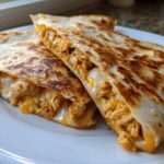 Close-up of crispy, golden-brown Cheesy Chicken Quesadilla triangles oozing melted cheese.