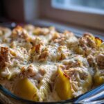 Close-up of baked Cheesy Chicken Stuffed Pasta shells covered in melted cheese and cream sauce.