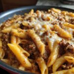Close-up of Cheesy Ground Beef Pasta Skillet with penne pasta, rich meat sauce, and melted mozzarella cheese topping.
