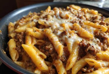 Close-up of Cheesy Ground Beef Pasta Skillet with penne pasta, rich meat sauce, and melted mozzarella cheese topping.