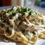 Close-up of a plate of Creamy Alfredo Chicken Pasta topped with fresh parsley.