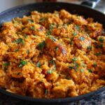 A close-up view of the finished Creamy Cajun Chicken and Rice Skillet, topped with fresh parsley.