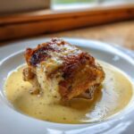 A single piece of Creamy Garlic Chicken Thighs with perfectly crispy, browned skin resting in a pool of rich garlic cream sauce.