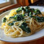 A close-up of Creamy Lemon Ricotta Pasta with Spinach tossed with spaghetti, served on a white plate.